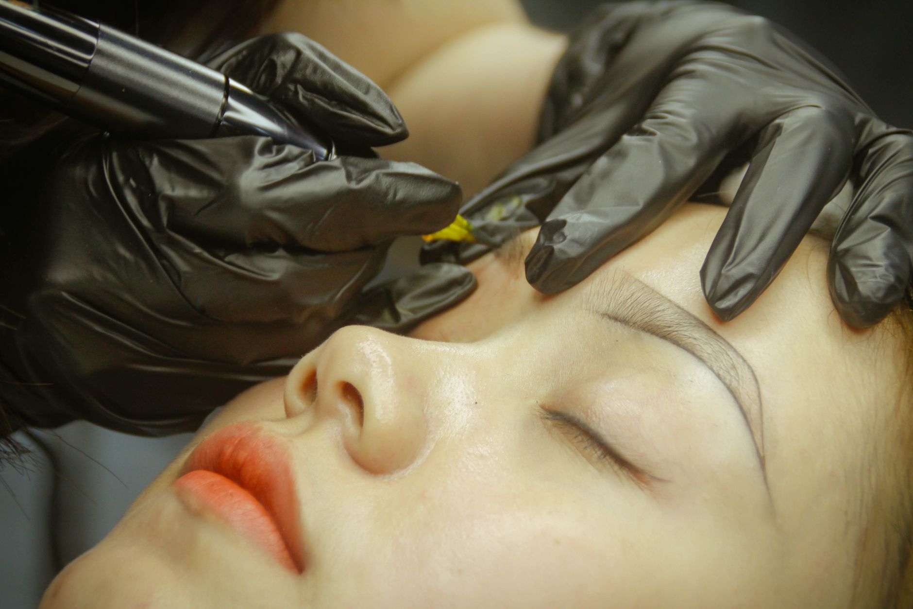 Dermógrafo aplicando pigmento na sobrancelha, em detalhe